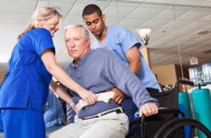2 operatori sanitari praticano la mobilizzazione di un paziente anziano infermo